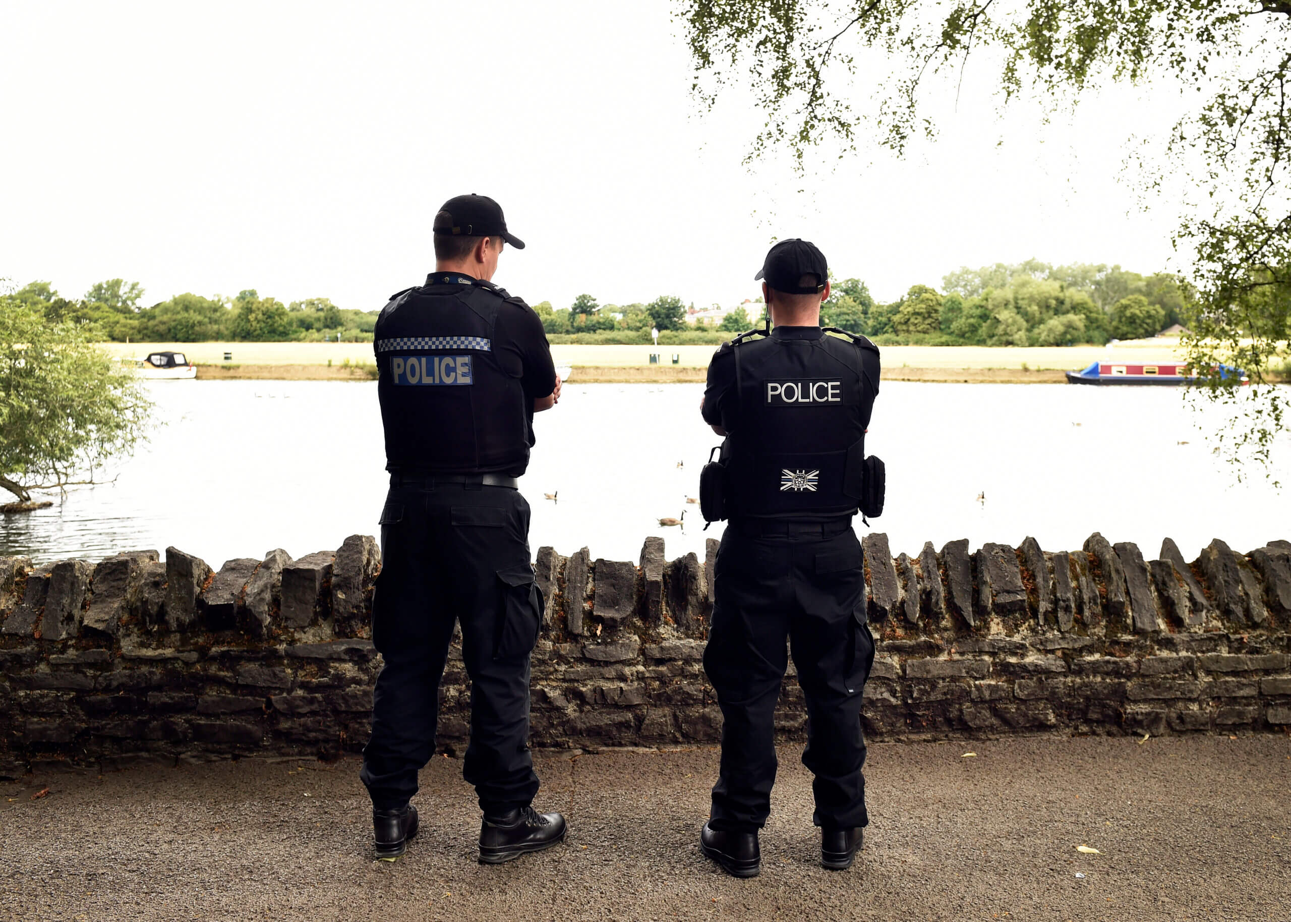 Police officers with caps on near river