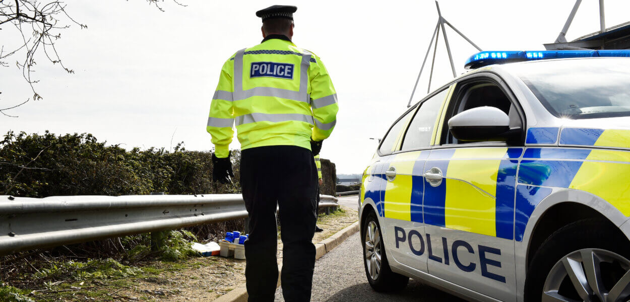 A police officer by a police car.