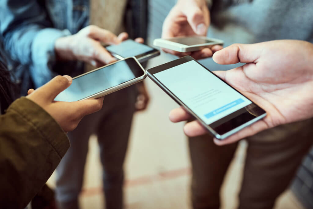Students, people and hands with phone in circle for network, connectivity and online information. University, friends and tech with screen at campus for communication, news and sharing test mark.