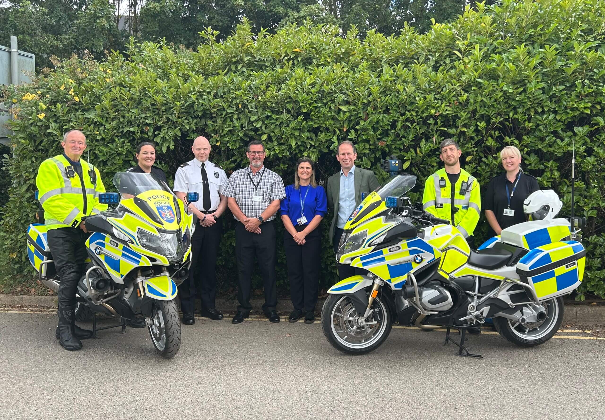 Thames Valley Police and Crime Commissioner, Matthew Barber, with officers and staff from TVP's Roads Policing Unit. The group of 8 are standing behind two of the enforcement motorbikes.